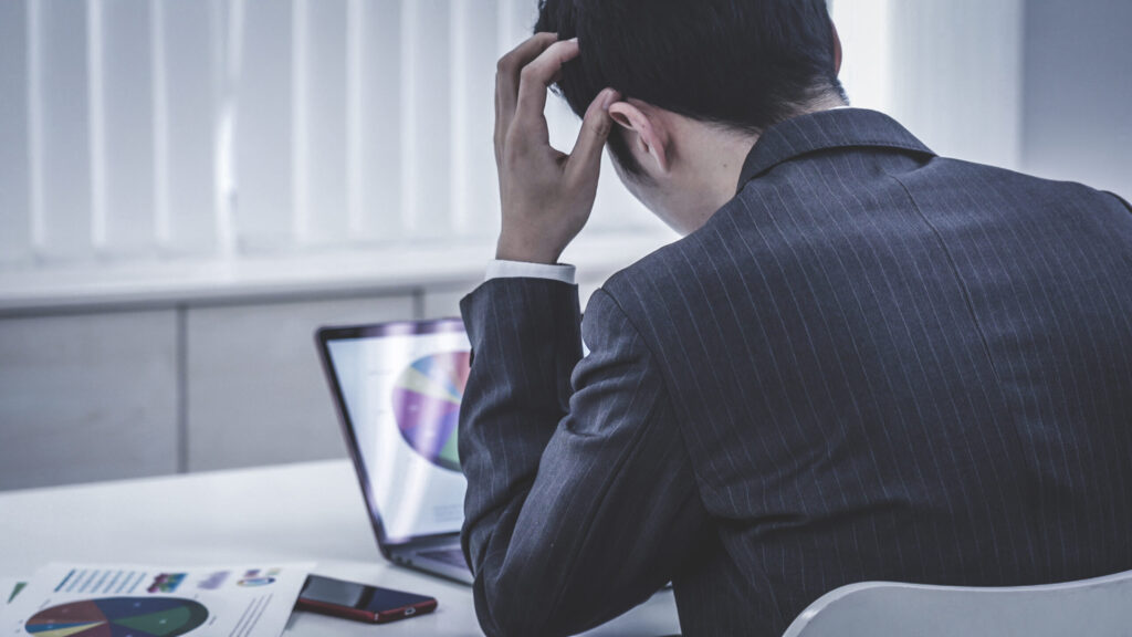 管理者が業務負担に頭を抱えている様子